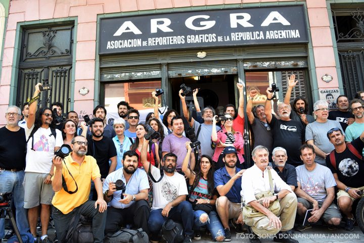 Un grupo de reporteros gráficos con la cámara en alto posan para una foto en frente de la sede de La Asociación de reporteros gráficos de la República Argentin