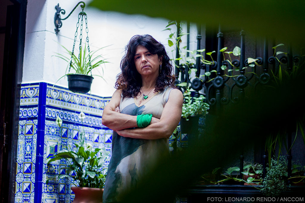 Eleona Ghioldi posando de brazos cruzados en un patio con algunas plantas.