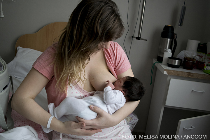 mujer dando de mamar a su bebe