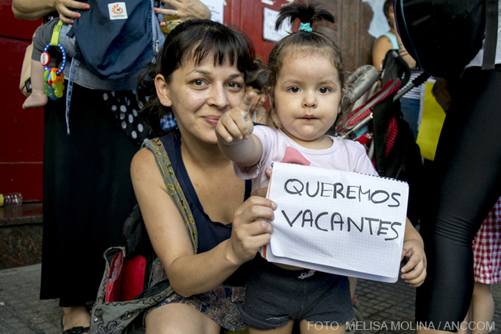una madre con su hija y un cartel que dice "queremos vacantes"