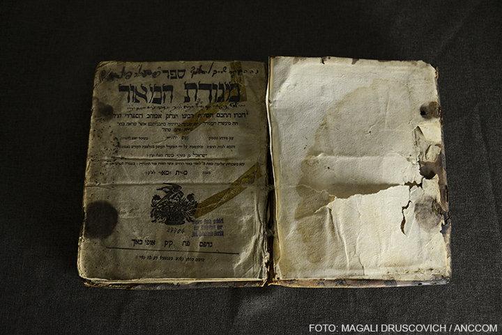 Un libro viejo escrito en hebreo y con sus páginas deterioradas.