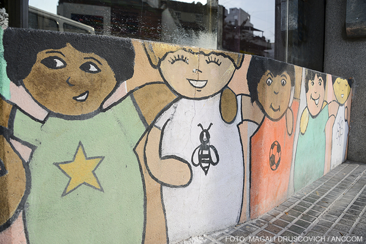 Una pared en la que se encuentran dibujados varios niños abrazados y sonriendo.