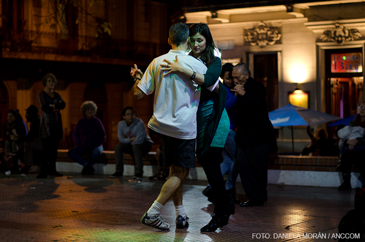 pareja bailando tango mientras otros estudiantes los miran.