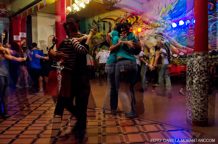 Muchas parejas bailando tango en el club.