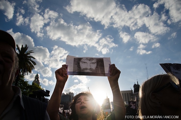 Mujer sosteniendo un cartel con el rostro de Santiago Maldonado, pidiendo justicia, en Plaza de Mayo.