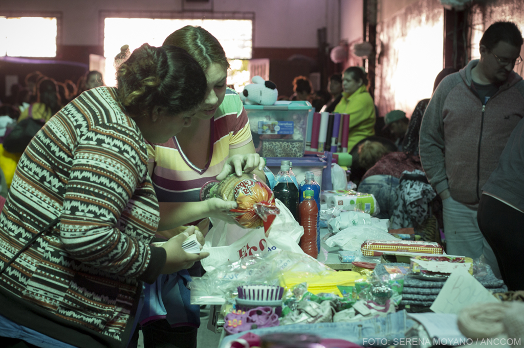 Dos mujeres revisan una bolsa de pan en el Mercado de trueque "Lulú".