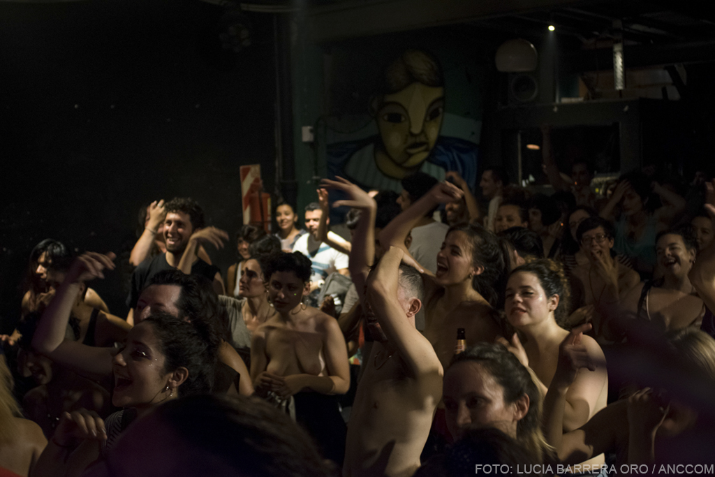 Público de Sudor Marika, mostrando sus torsos desnudos, escuchando la banda.