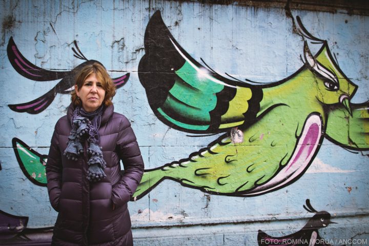 Daiana Malamud posando frente a un mural con un pájaro verde detrás