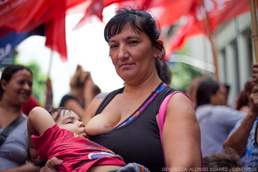 Mujer amamantando a su hijo durante un manifestación.