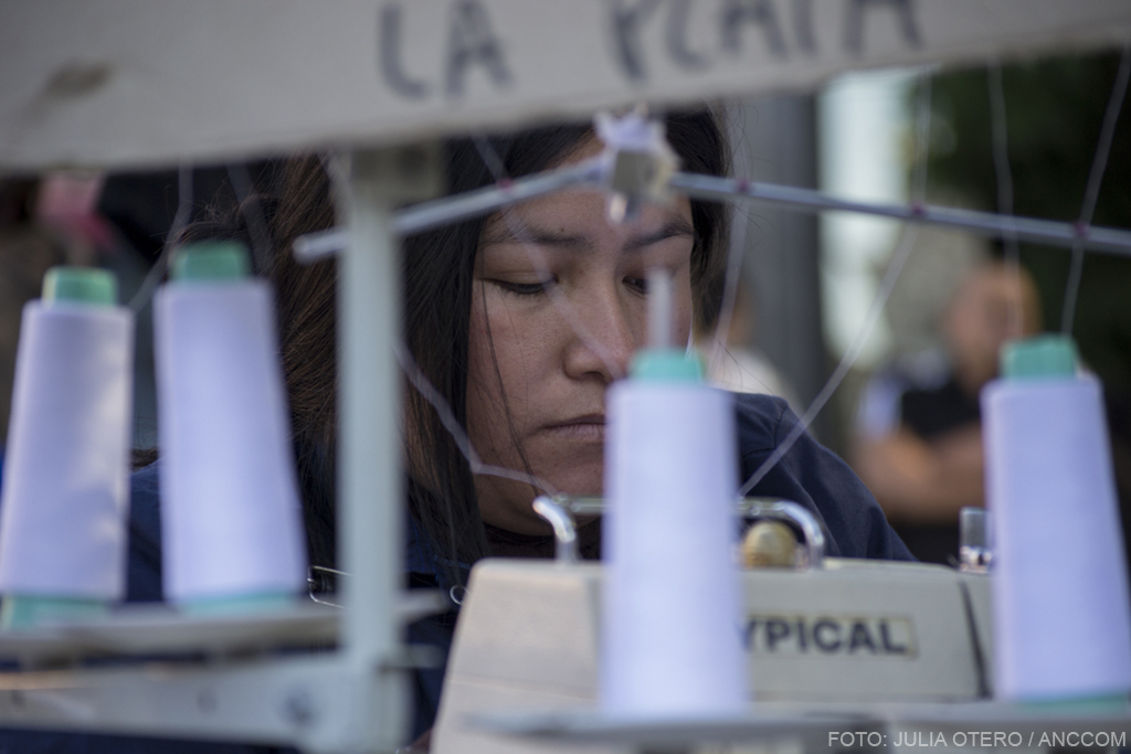 Una mujer trabaja en el marco de la jornada "Cocer en la Calle" como forma de protesta por la finalización del programa "Proveedores del Estado"