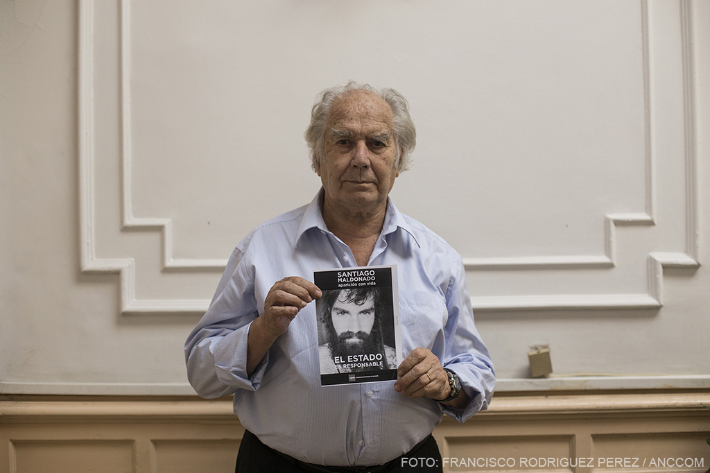 Adolfo Pérez Esquivel sosteniendo una cartel con la imagen de Santiago Maldonado.