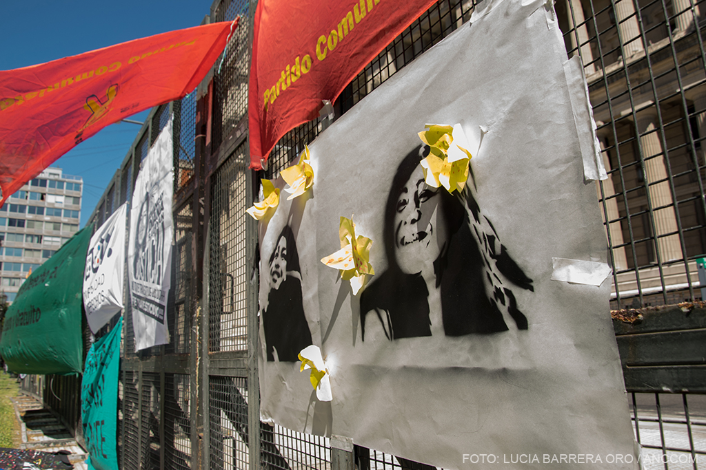 Banderas y carteles con la imagen de Amancay Diana Sacayán colgados de una reja, el día del inicio al juicio por su travesticidio.