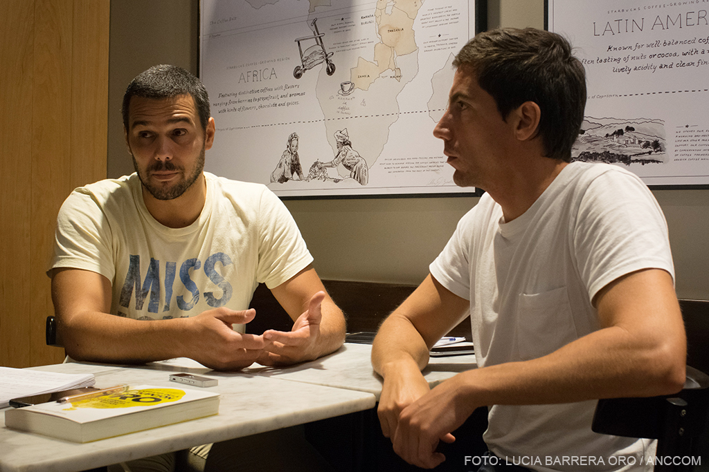 Julián Maradeo e Ignacio Damiani dan la entrevista sentados en una mesa de trabajo, sobre la cual se ve el libro de su autoría.
