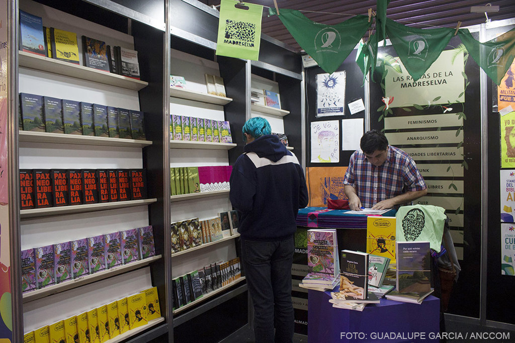 Una persona mira los libros del stand de la Editorial Madreselva en la Feria del Libro.
