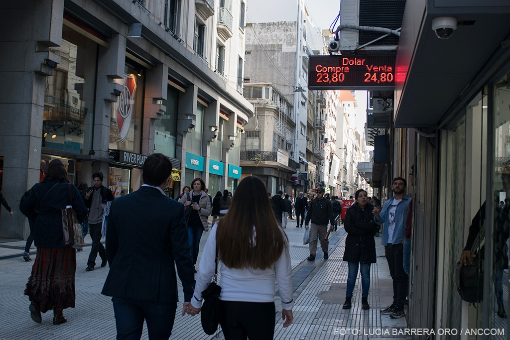 La city porteña, con gente que camina por la calle y mira los carteles de la cotización de la moneda extranjera.