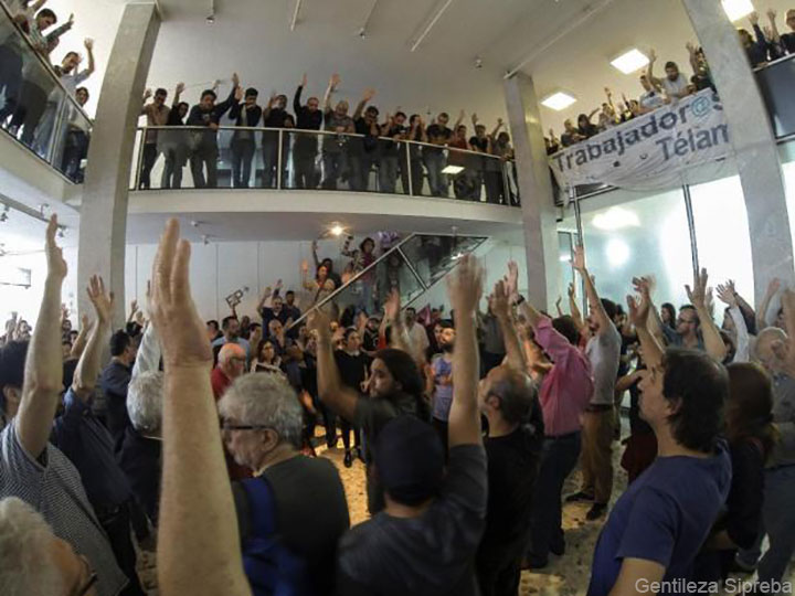 Asamblea de trabajadores de Télam levantan la mano en una votación.