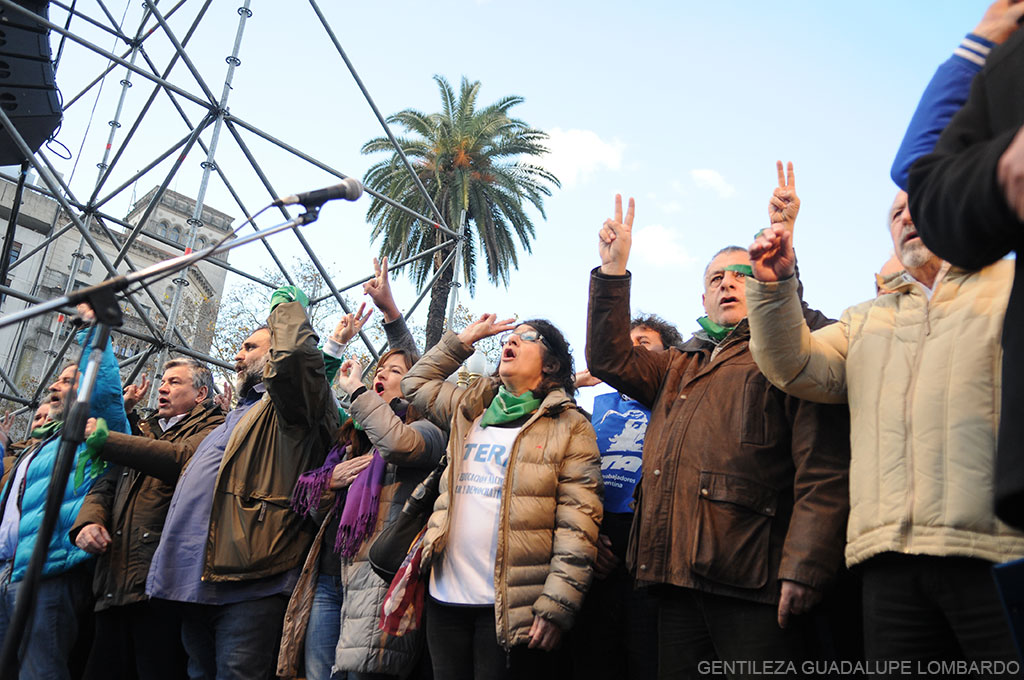 Dirigentes sindicales sobre el escenario levantando sus manos.