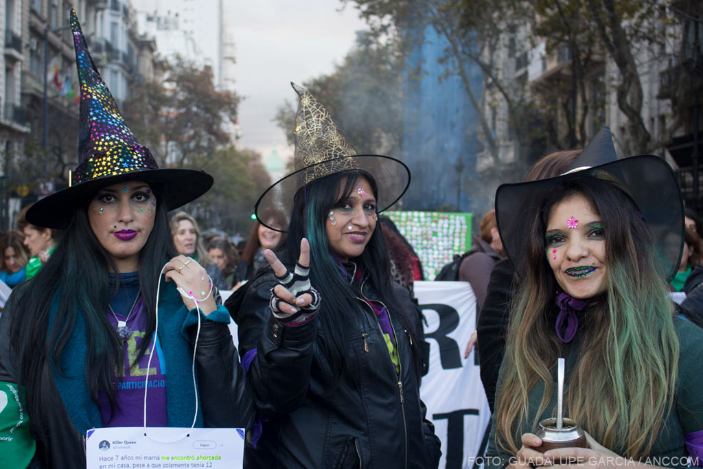 Tres mujeres con sombreros de brujas y sus caras pintadas.