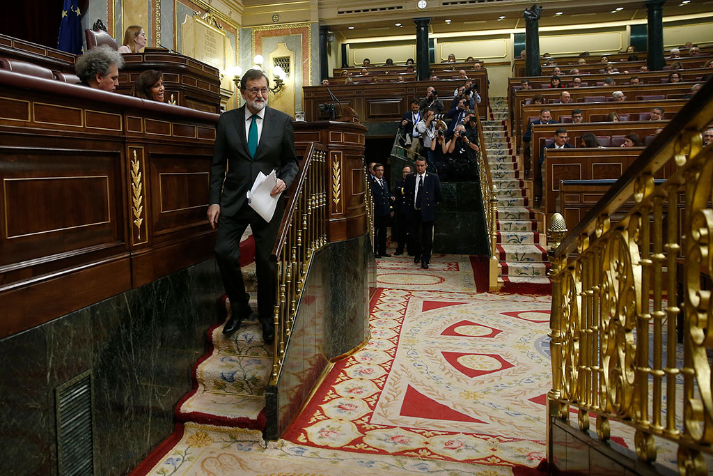 Rajoy baja una escalera del parlamento español, luego de su último discurso como presidente.