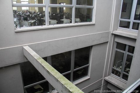 Pulmón interno del edificio de la facultad, donde se visualizan aulas con sillas vacías.
