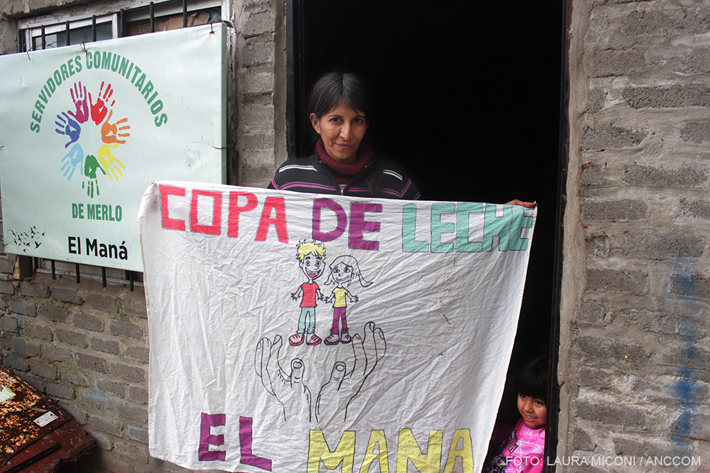 Mujer sosteniendo tela, en donde se lee "copa de leche El Maná"