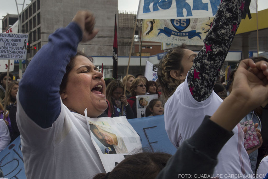 Mujeres alzando el puño y cantando en la movilización. 