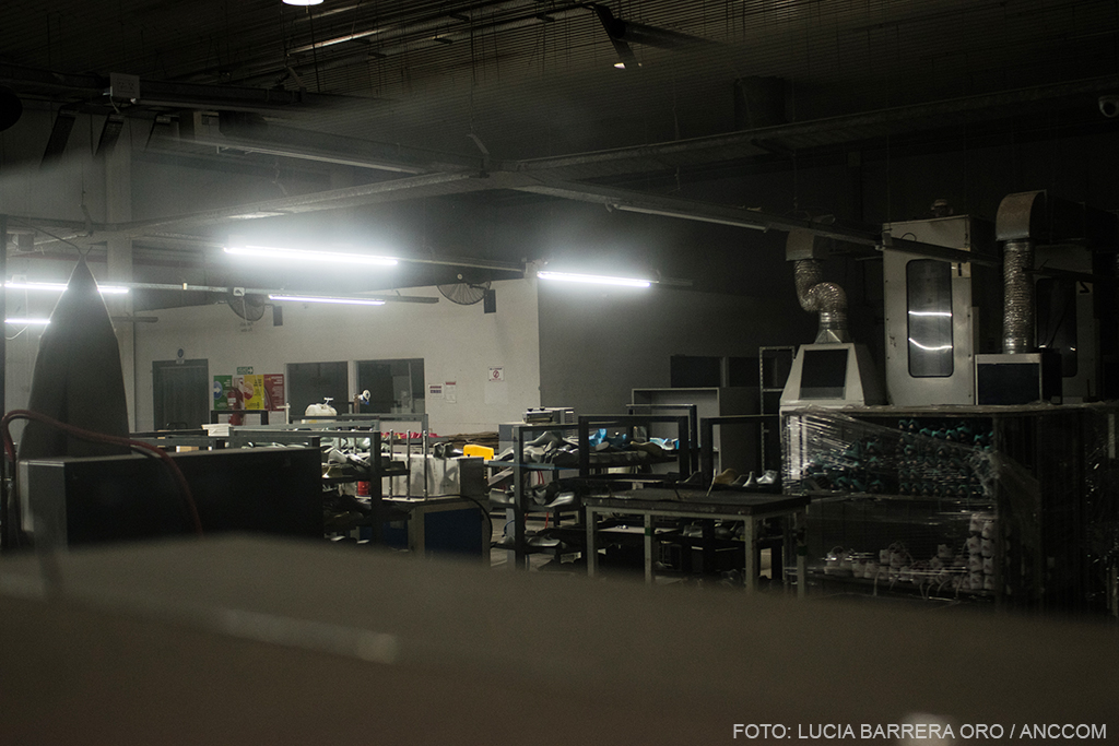 Interior de una fábrica, con máquinas y materiales. 